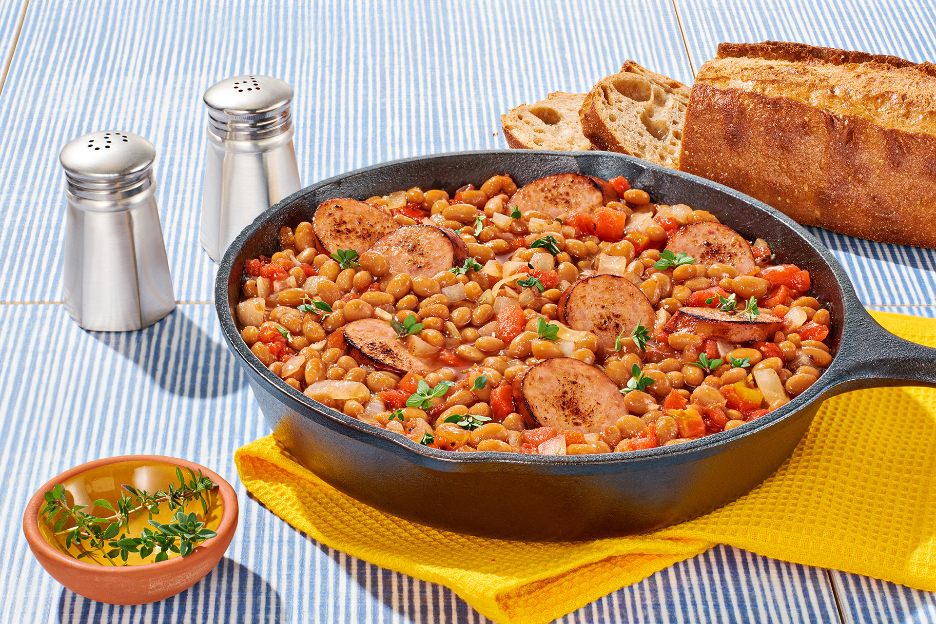 Baked bean and sliced sausage casserole in a cast iron skillet