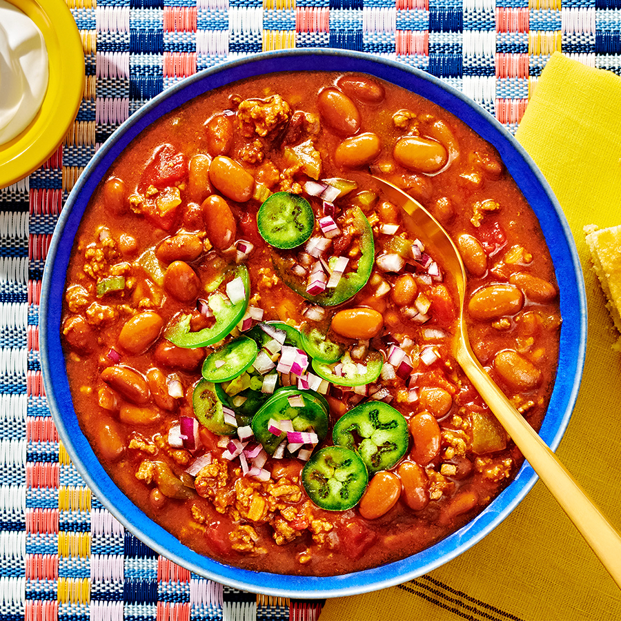 A Bowl of chili topped with jalapenos