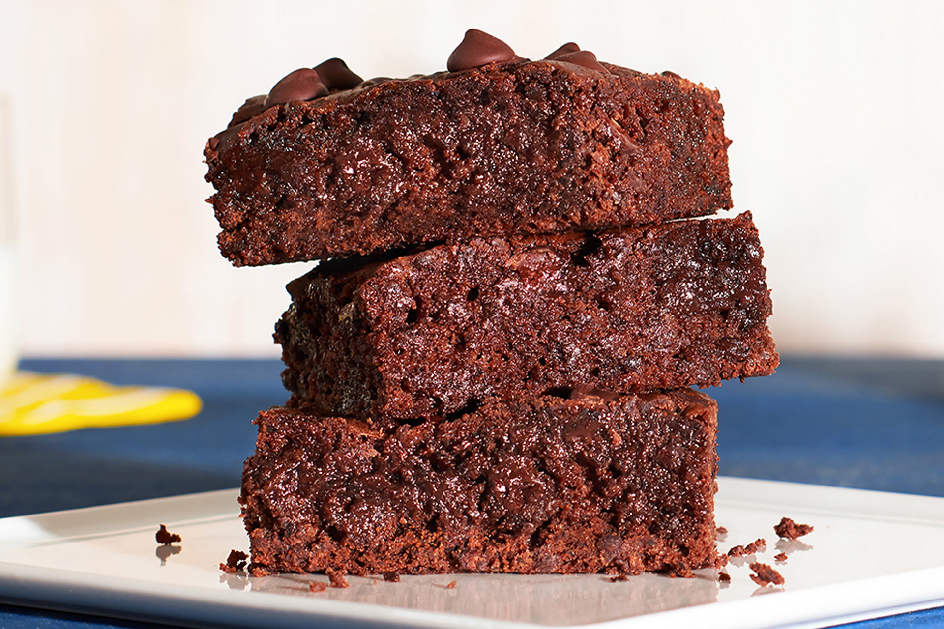 A close-up of three black bean and dark chocolate brownies stacked on top of each other