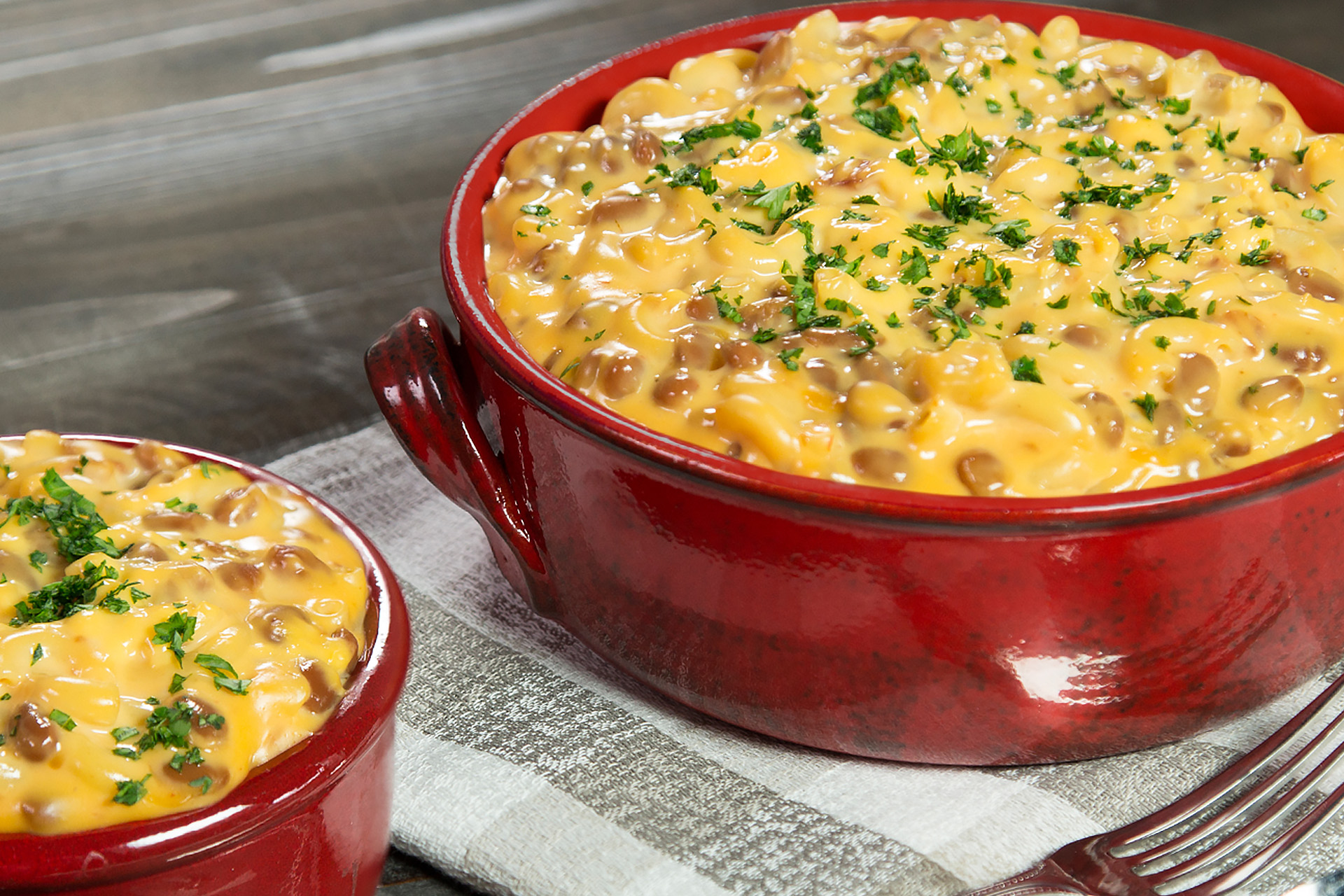 Baked bean and bacon mac and cheese in a dark red crock