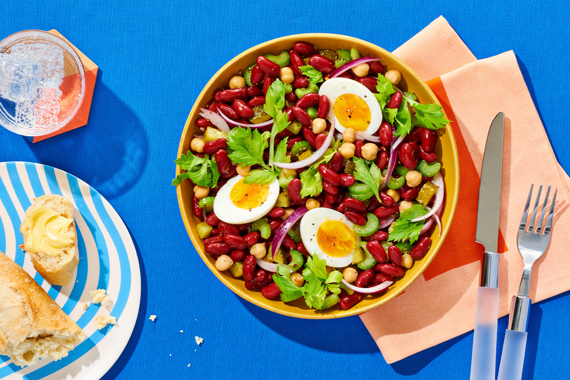 Colorful kidney bean salad with chickpeas, parsley and hard-boiled eggs in yellow bowl