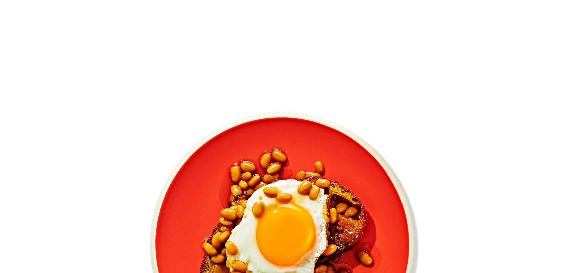 Red plate with an egg and brown beans on it