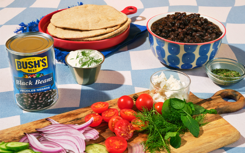 ingredients for greek-style black bean smashburgers spread out on a checkered tablecloth