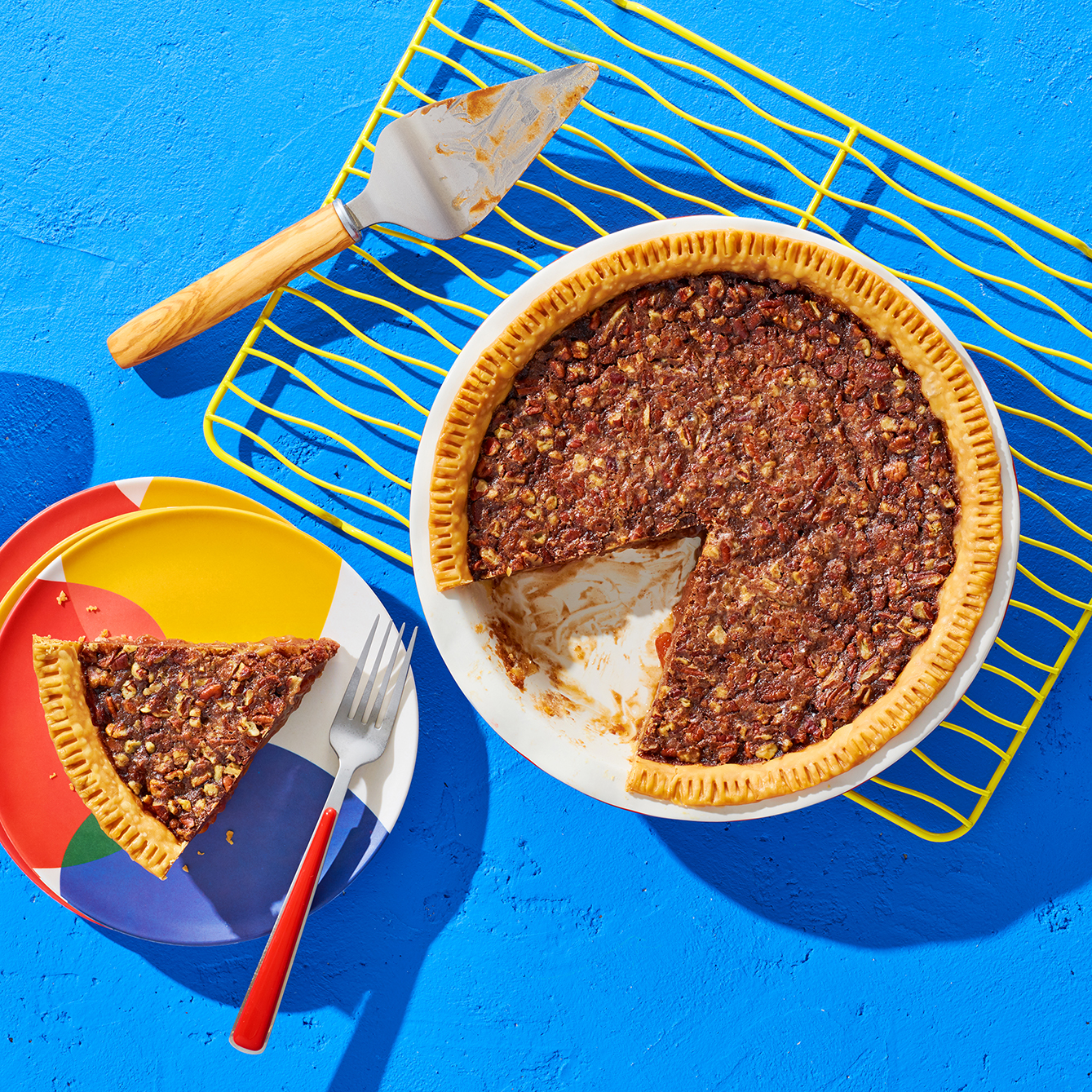 A chocolate pinto pie with one slice on a plate.