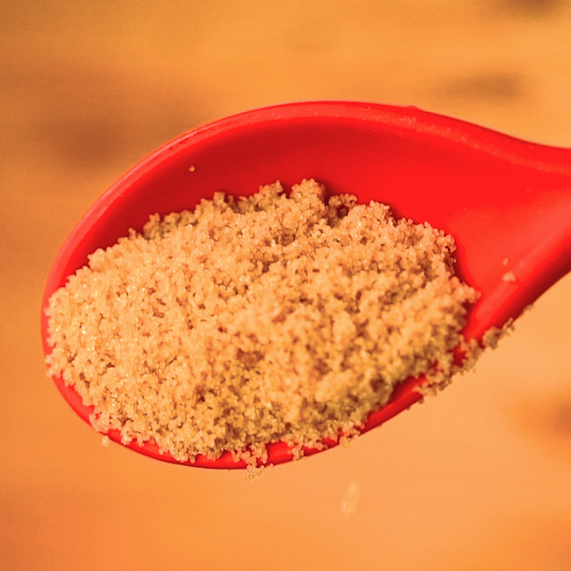 Red spoon full of brown sugar