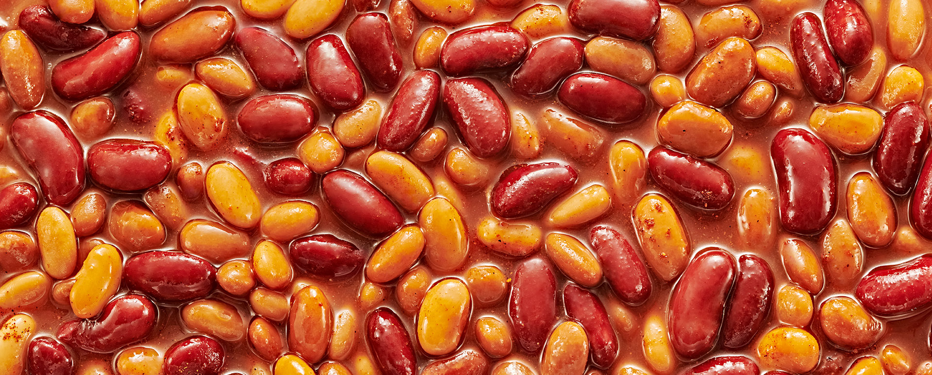 A close-up of red and light kidney beans being cooked