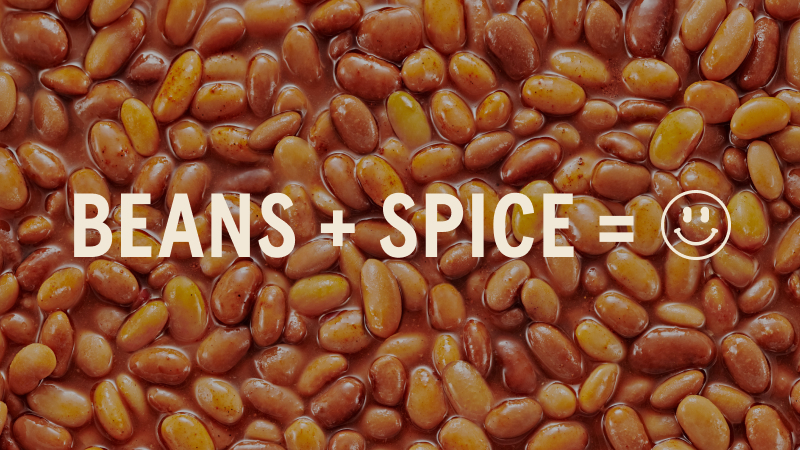 Close-up of baked beans with overlayed text BEANS + SPICE 