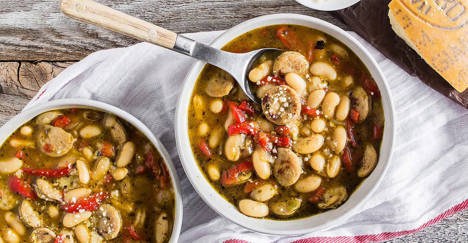 Cannelini bean and sweet Italian sausage in white bowl with spoon