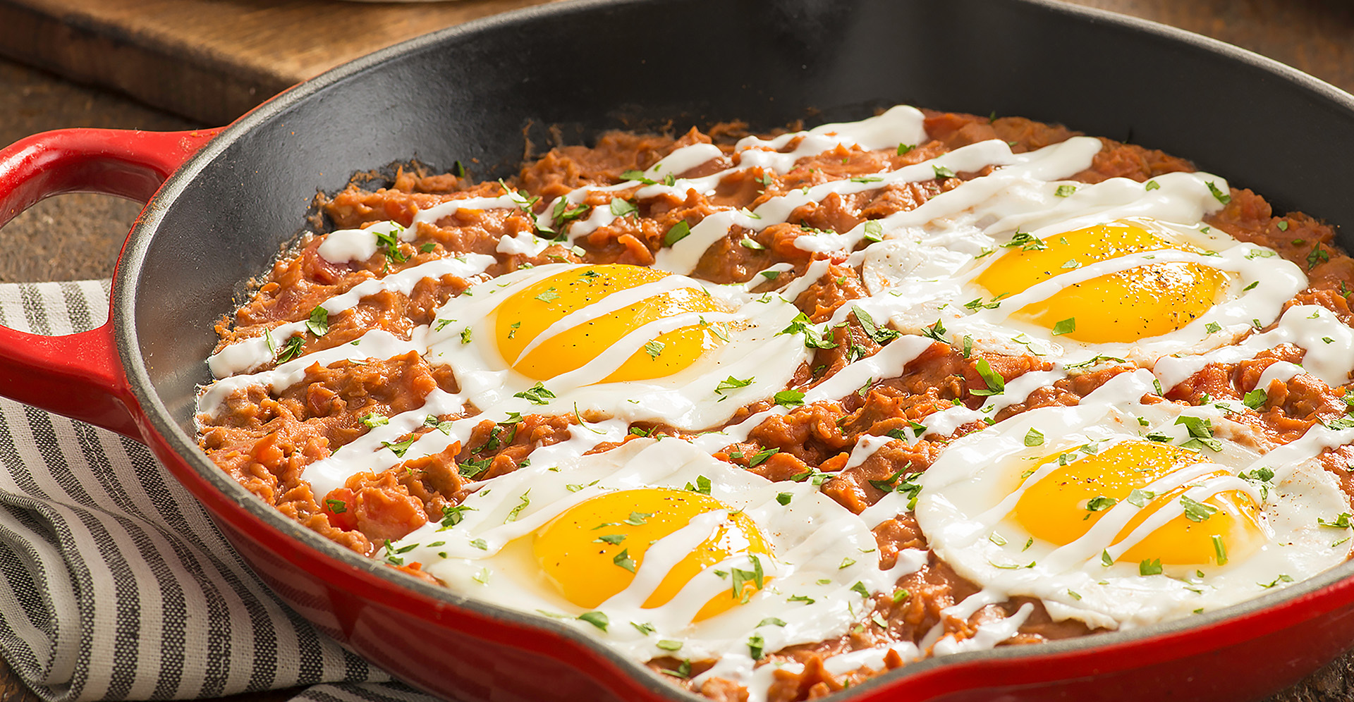 Refried bean, chorizo and tomato skillet topped with sunny side up eggs