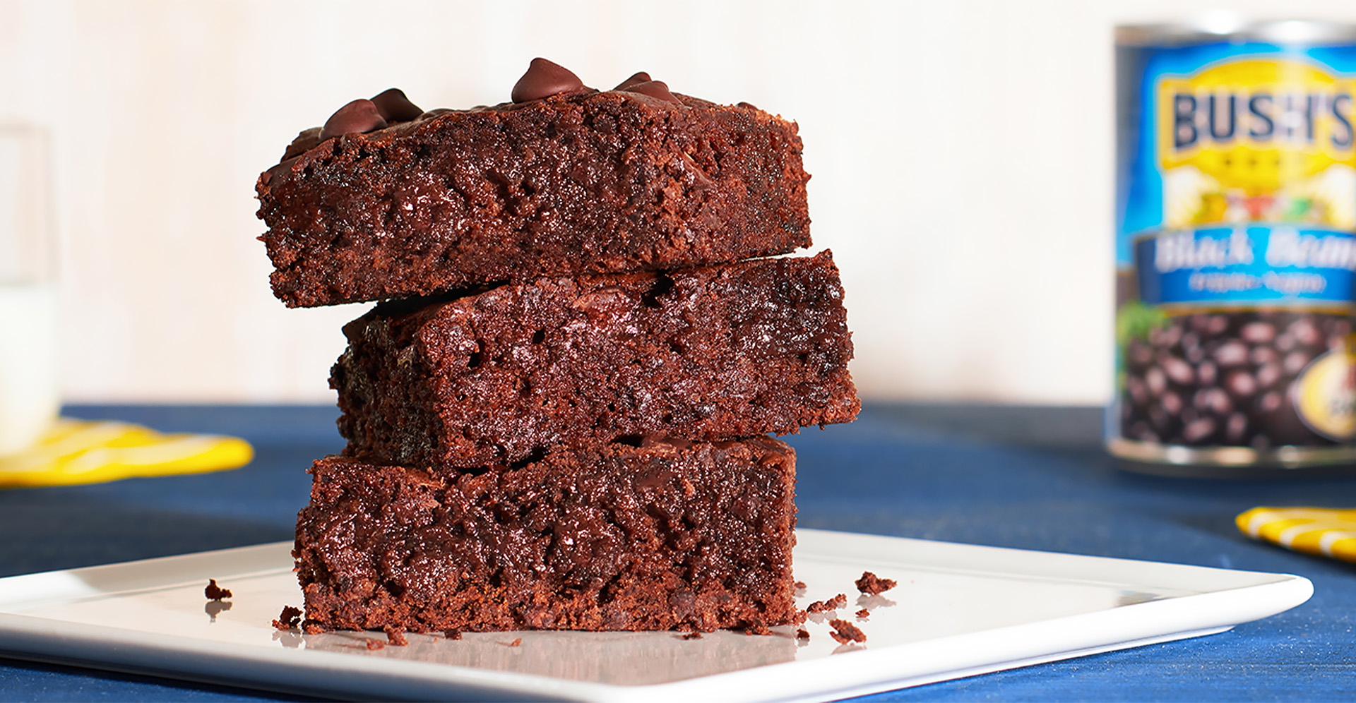 A close-up of three black bean and dark chocolate brownies stacked on top of each other