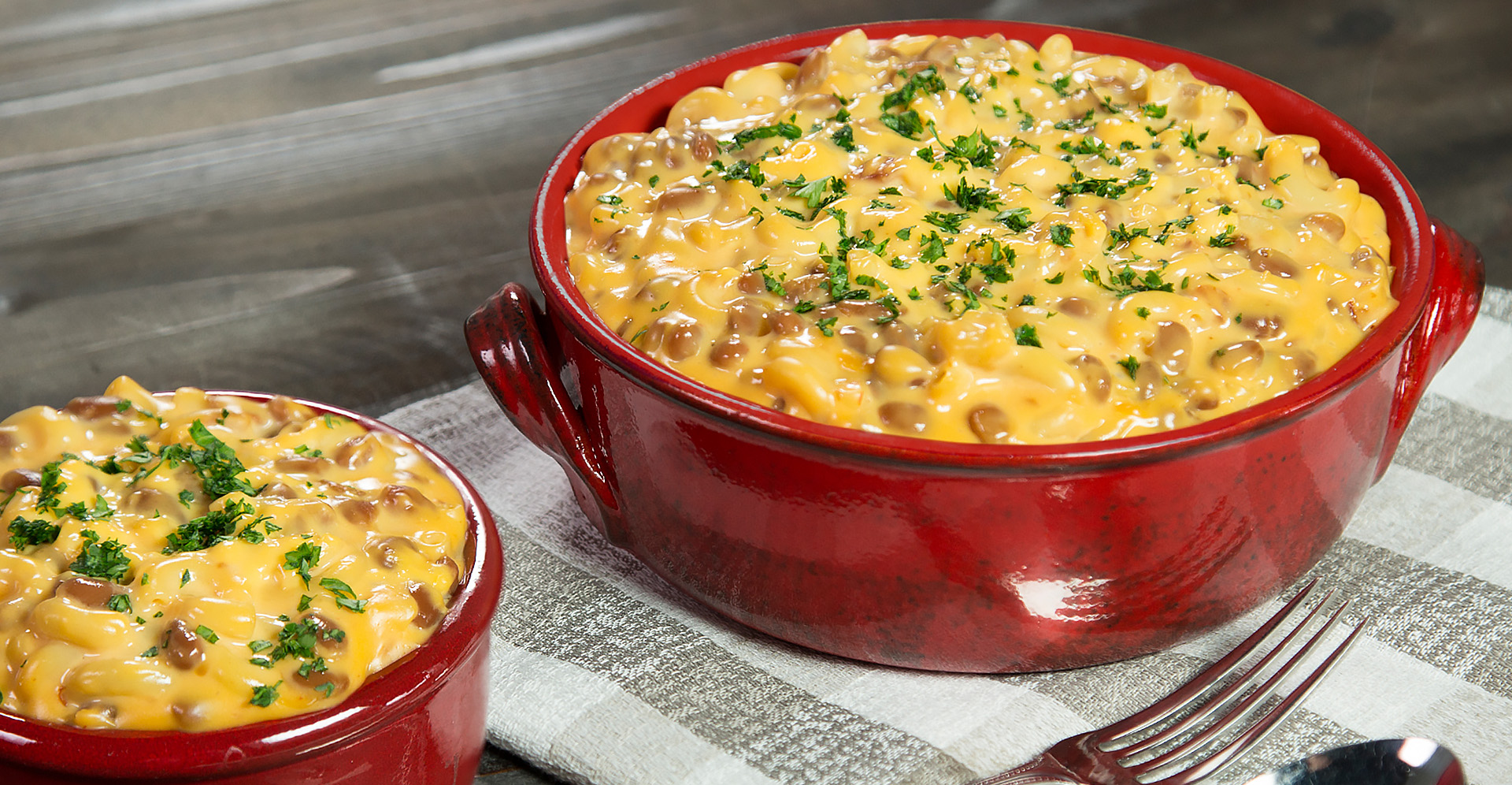 Baked bean and bacon mac and cheese in a dark red crock