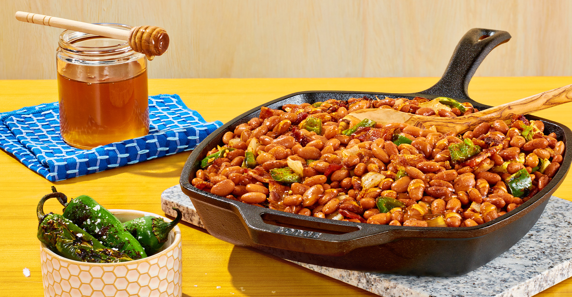 Chipotle pinto beans with bacon, garlic and honey in a square cast iron skillet