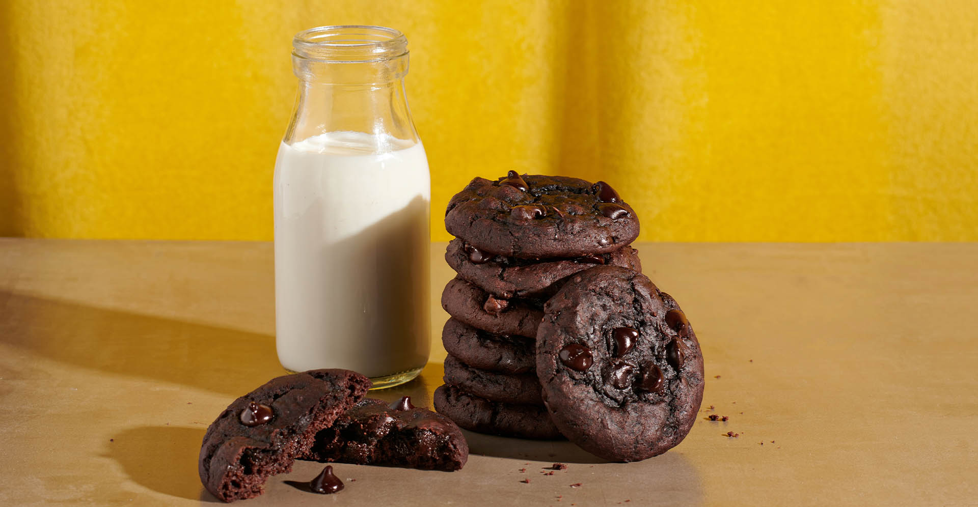 Stack of chocolate fudge and black bean cookies with a glass of milk.