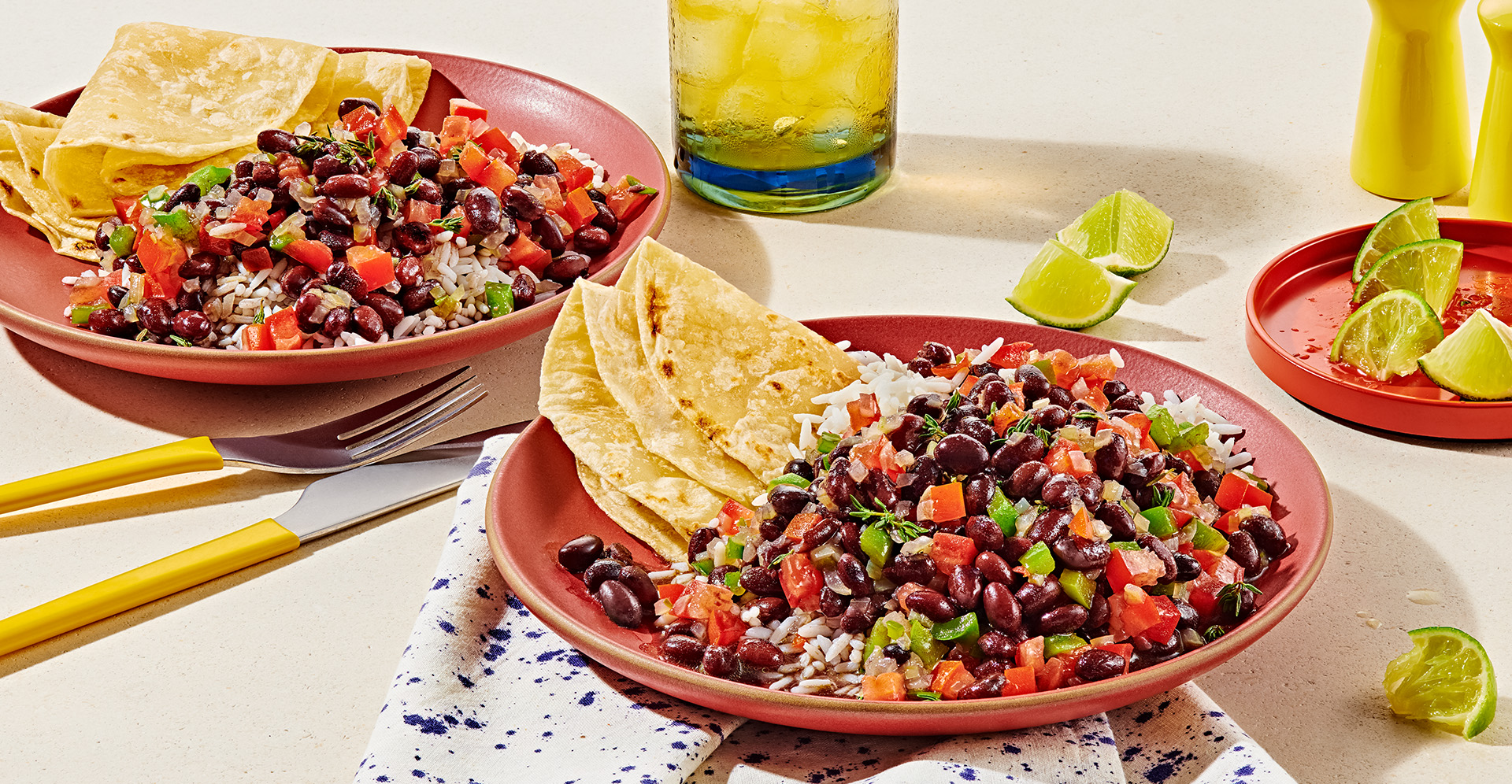 Black beans and rice with tortillas on a red plates