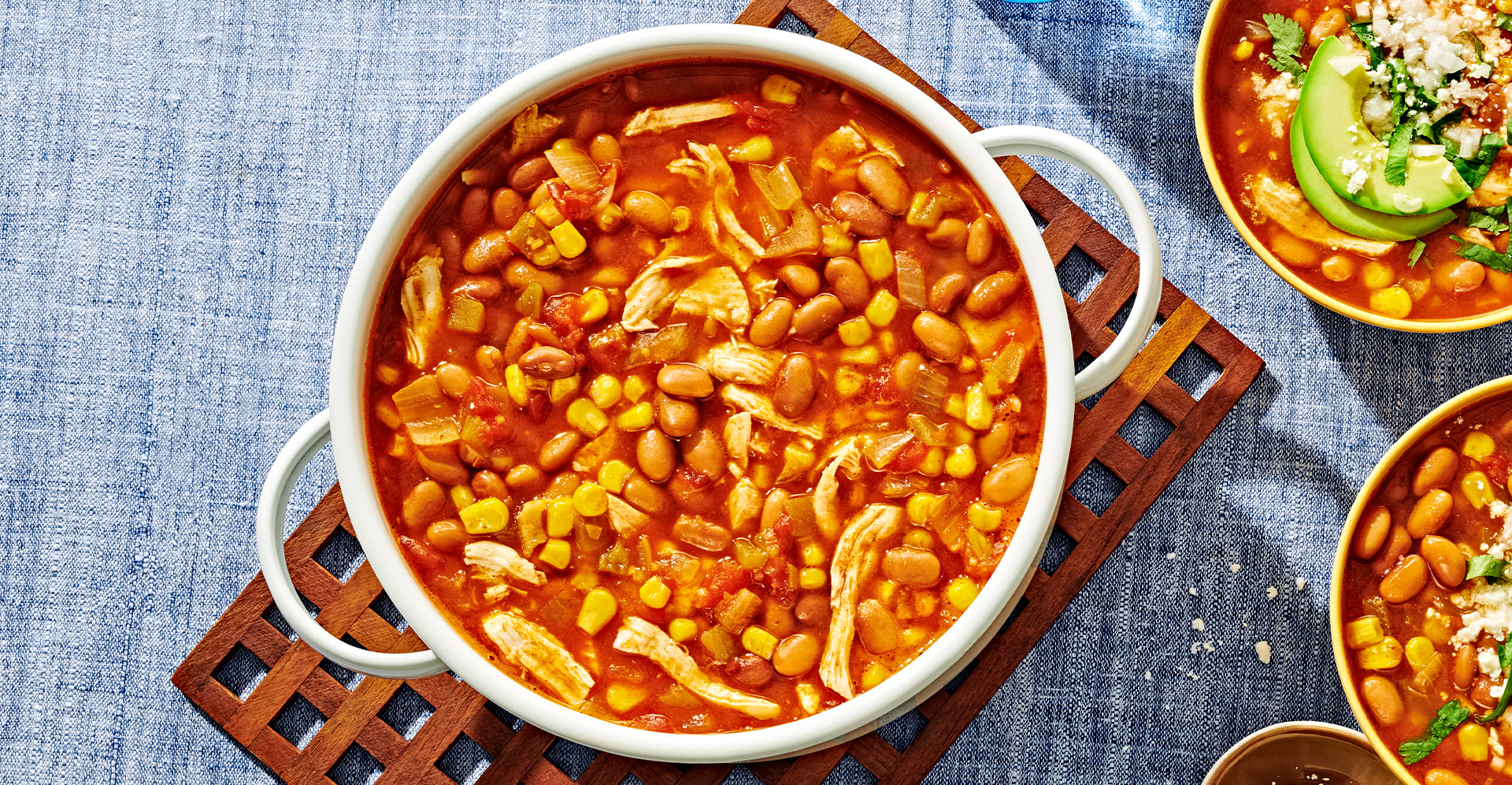 Chicken tortilla soup with beans in a white pot