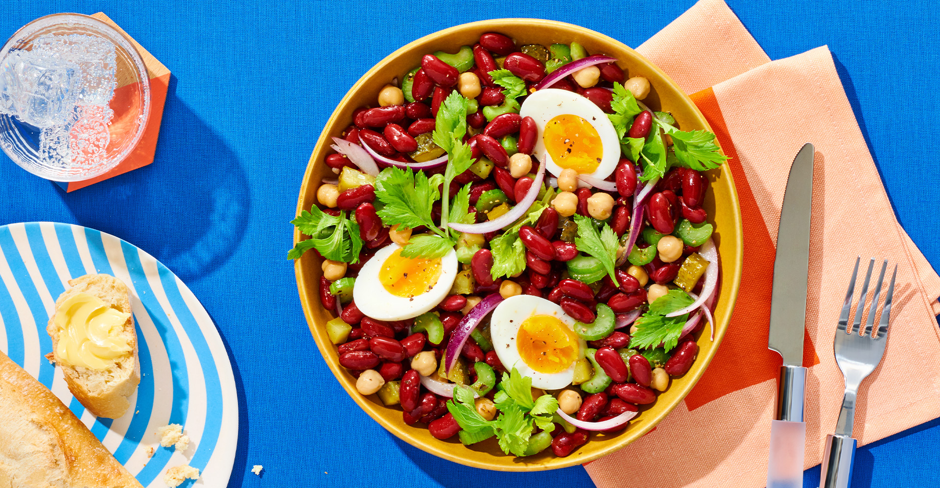 Colorful kidney bean salad with chickpeas, parsley and hard-boiled eggs in yellow bowl