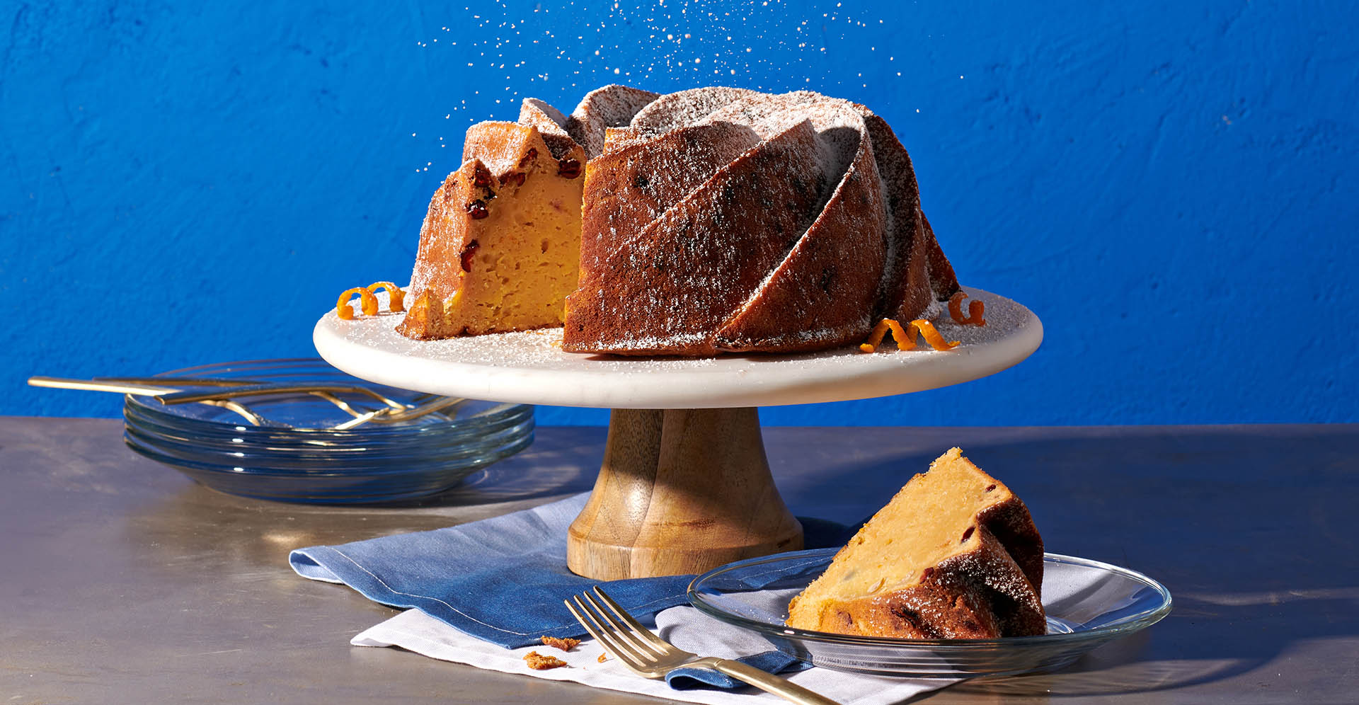 Sweet garbanzo bean cake with powdered sugar and orange rind with one slice.