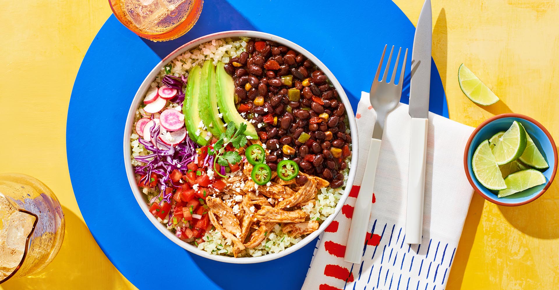 A cauliflower rice and Bush's Black Bean Fiesta bowl topped with avocado, tomatoes and chicken