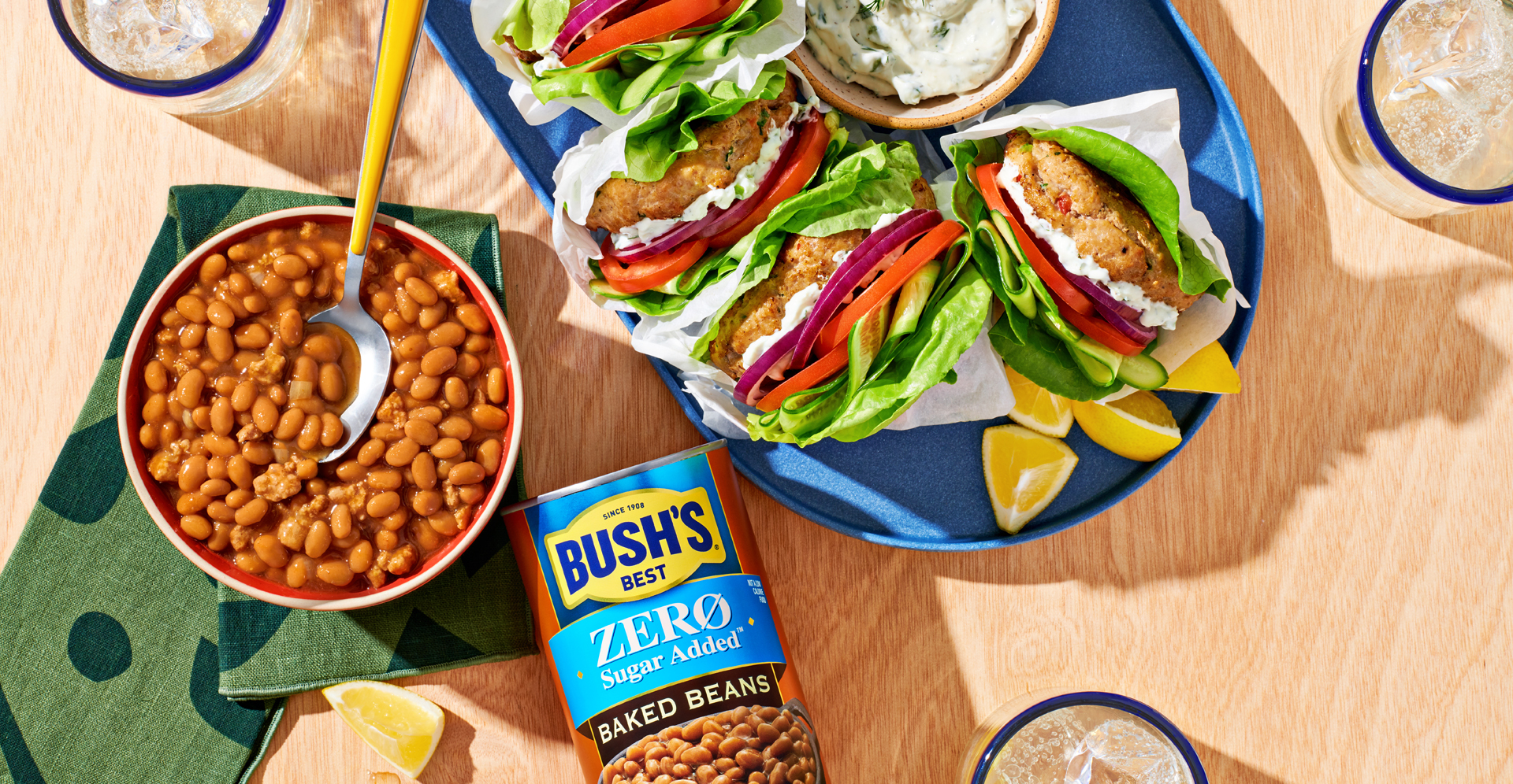 A bowl of baked beans next to a can of Bush's Zero Sugar Added Baked Beans