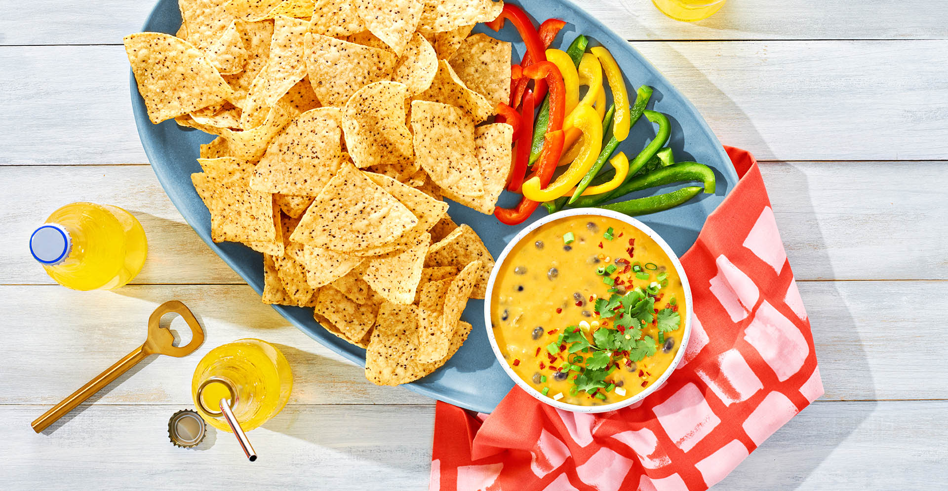 Plato de salsa de frijoles negros con queso con chips de maíz y rebanadas de pimientos.